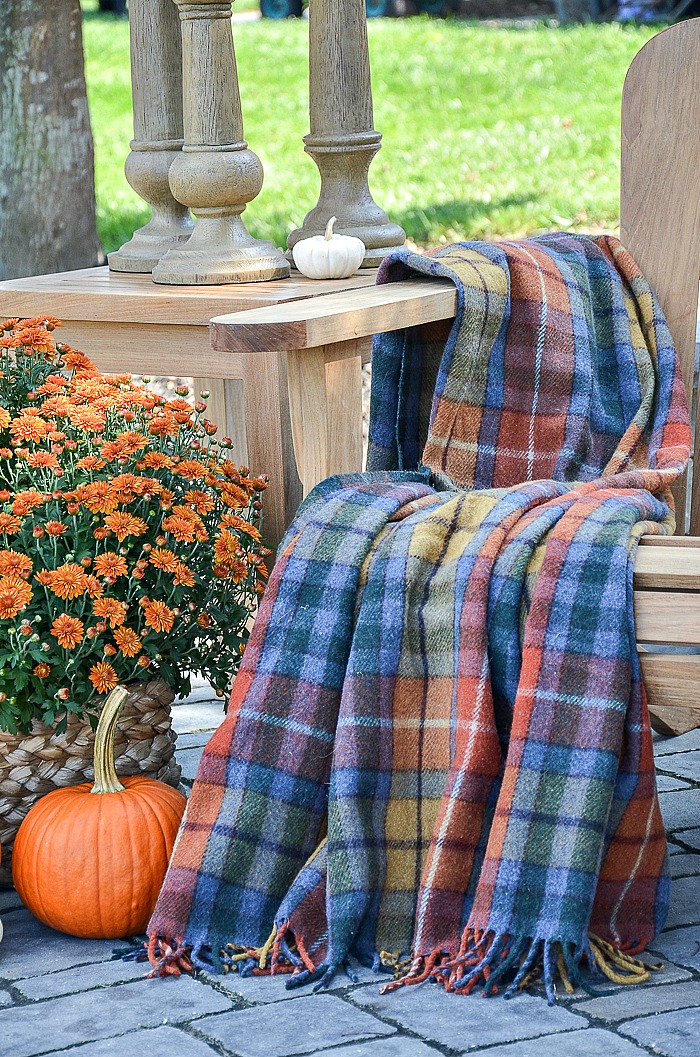 Cozy Outdoor Fall Nook with Plaid Blanket and Pumpkins