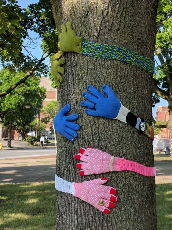 20 Whimsical Tree Trunk Projects That Transform Your Outdoor Space DIY Tree Hugs with Colorful Glove Arms