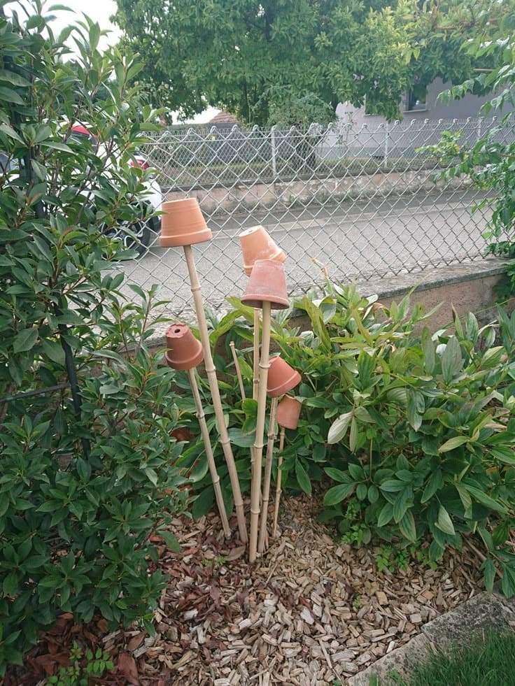 Leaning Terracotta Pot Sculptures On Bamboo Sticks