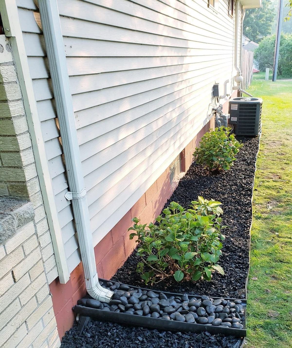 Sleek Rock-Lined Downspout Extension